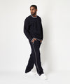 CUSTOM_ALT_TEXT: Male model wearing Paper Planes Racked Rib Sweater and Pant, color Parisian Night.