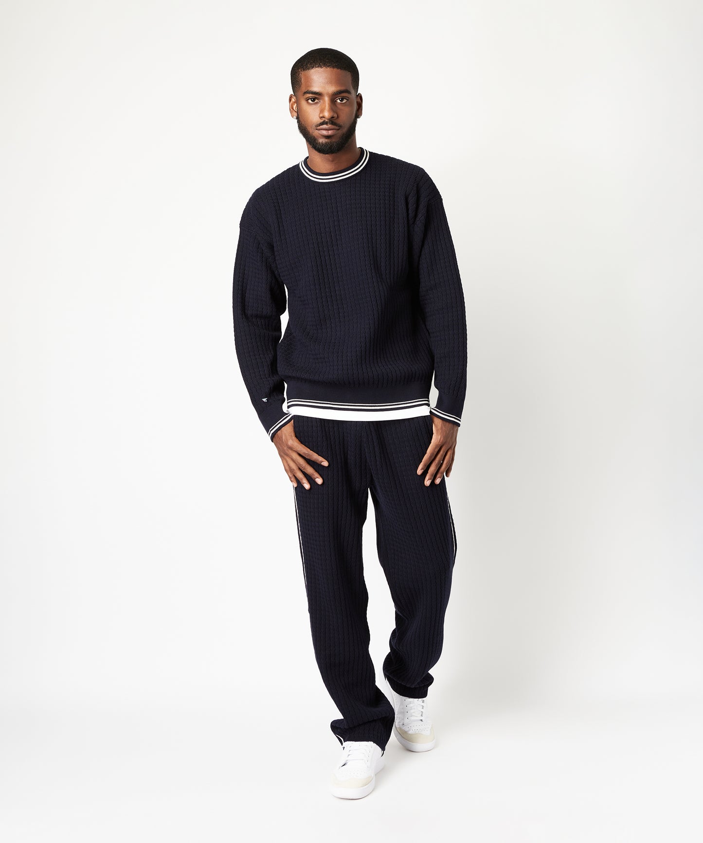 CUSTOM_ALT_TEXT: Male model wearing Paper Planes Racked Rib Sweater and Pant, color Parisian Night.