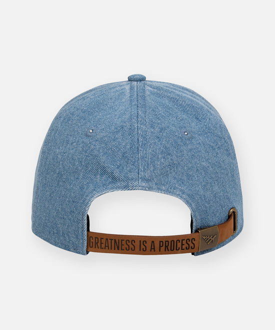 CUSTOM_ALT_TEXT: Embossed leather backstrap with antique brass buckle on Paper Planes PPL Dad Hat, color Indigo.