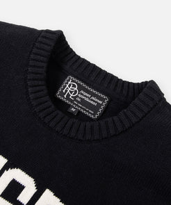 CUSTOM_ALT_TEXT: Ribbed neck and main woven label on Paper Planes Trusted Crewneck Sweater.
