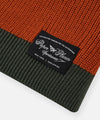 CUSTOM_ALT_TEXT: Paper Planes Sportswear woven label  on Paper Planes Striped Crewneck Sweater, color Ginger.
