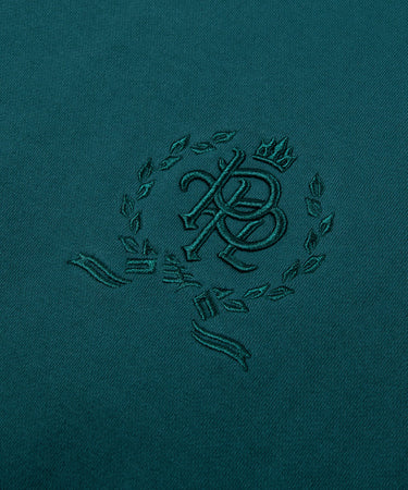 CUSTOM_ALT_TEXT: 3-D embroidered PPL chest crest on Paper Planes Crest Hoodie, color Atlantic Deep.