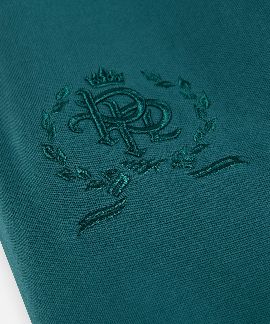  3-D embroidered PPL crest on right thigh of Paper Planes Crest Sweatpant, color Atlantic Deep.