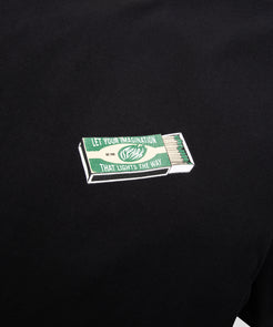 CUSTOM_ALT_TEXT: Closeup of matchbox graphic on front of Paper Planes The Spark Tee, color Black.