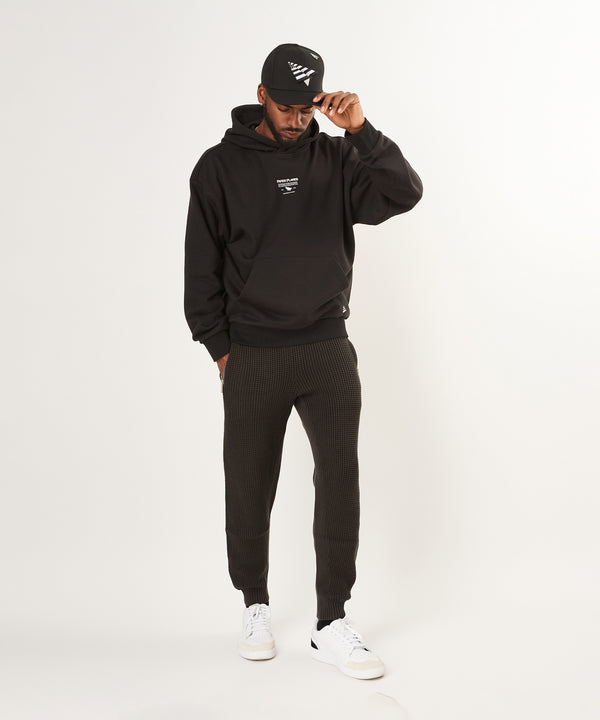 CUSTOM_ALT_TEXT: Male model wearing Paper Planes Mantra Hoodie and Sweater Knit Jogger.