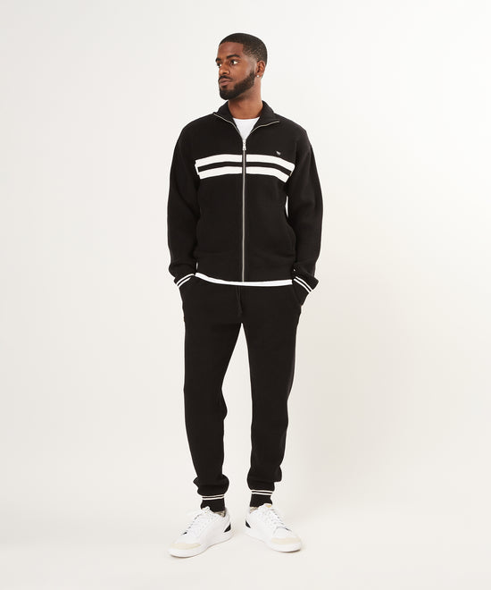 CUSTOM_ALT_TEXT: Male model wearing Paper Planes Sweater Track Jacket and Jogger, color Black.