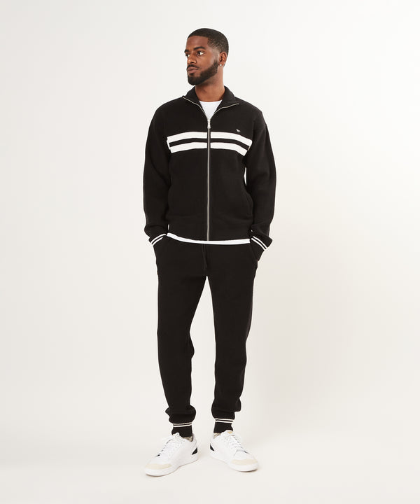 CUSTOM_ALT_TEXT: Male model wearing Paper Planes Sweater Track Jacket and Jogger, color Black.