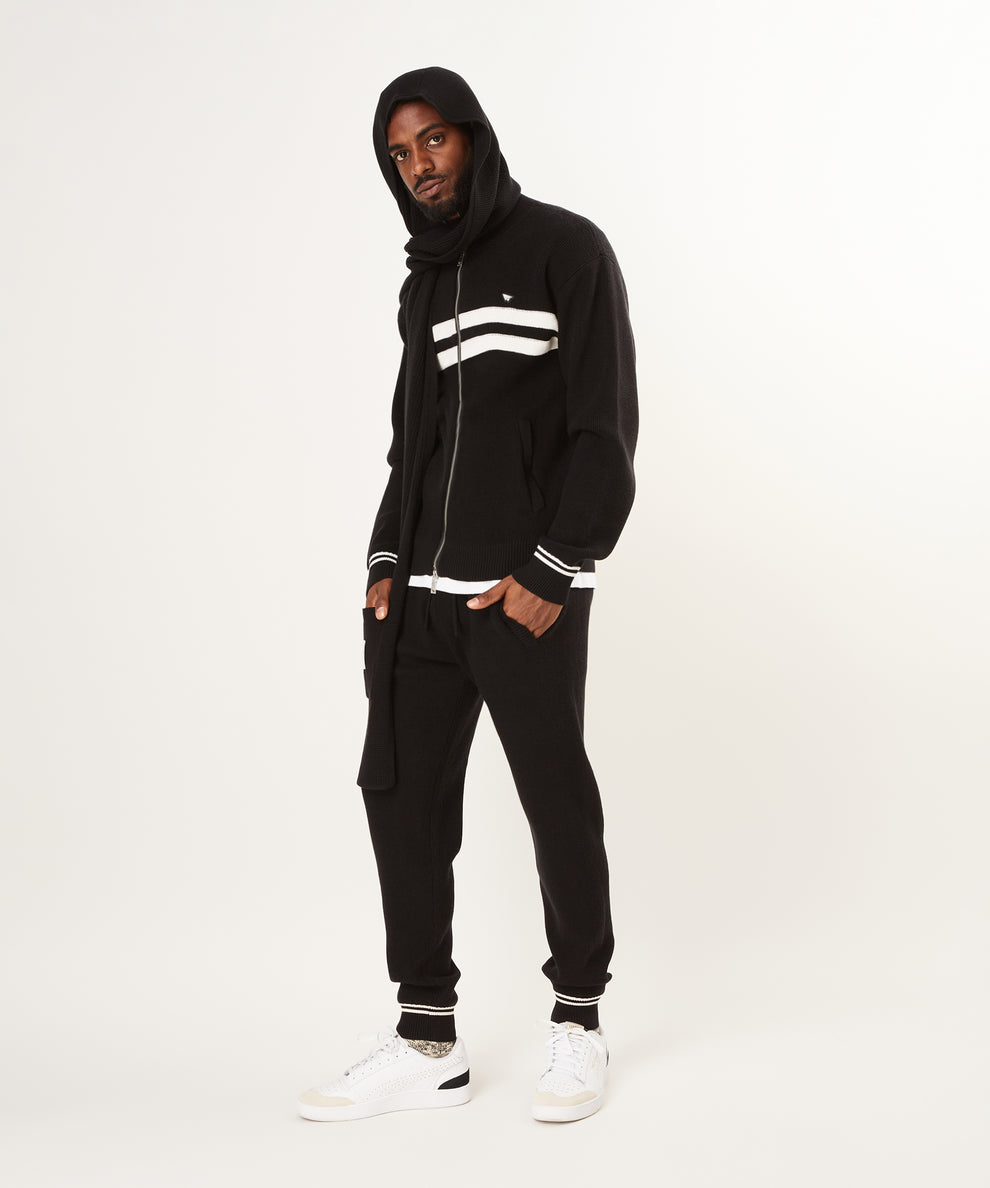 CUSTOM_ALT_TEXT: Male model wearing hoodie and Paper Planes Sweater Track Jacket and Jogger, color Black.