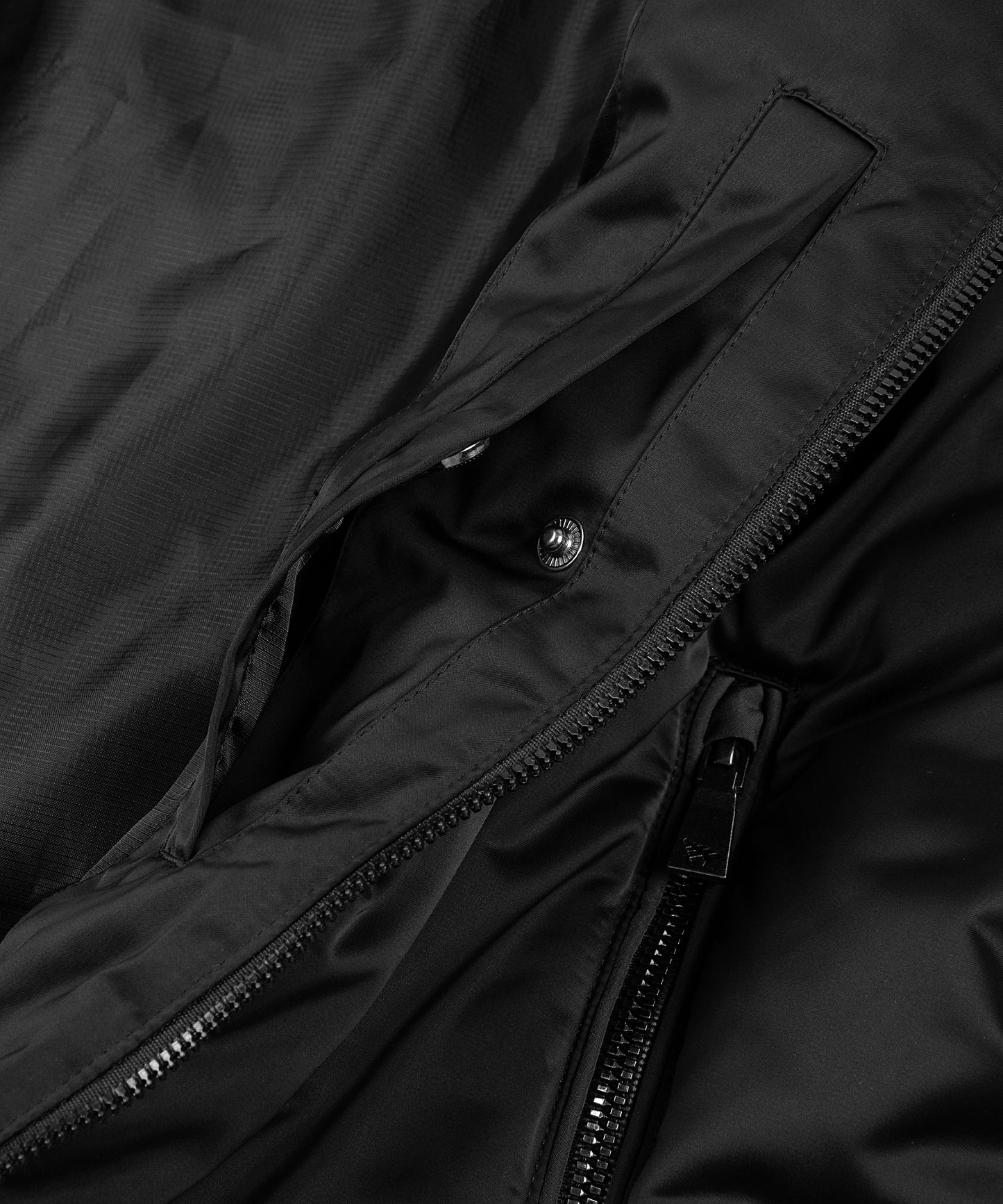 CUSTOM_ALT_TEXT: Interior welt pocket with hidden snap closure on Paper Planes Puffer Jacket, color Black.