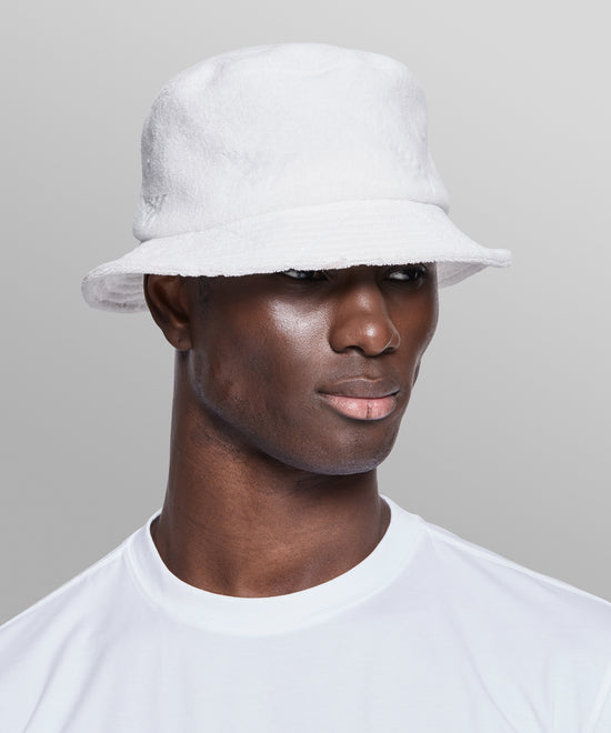 CUSTOM_ALT_TEXT: Male model wearing Paper Planes Jacquard Terry Cloth Bucket Hat color White.