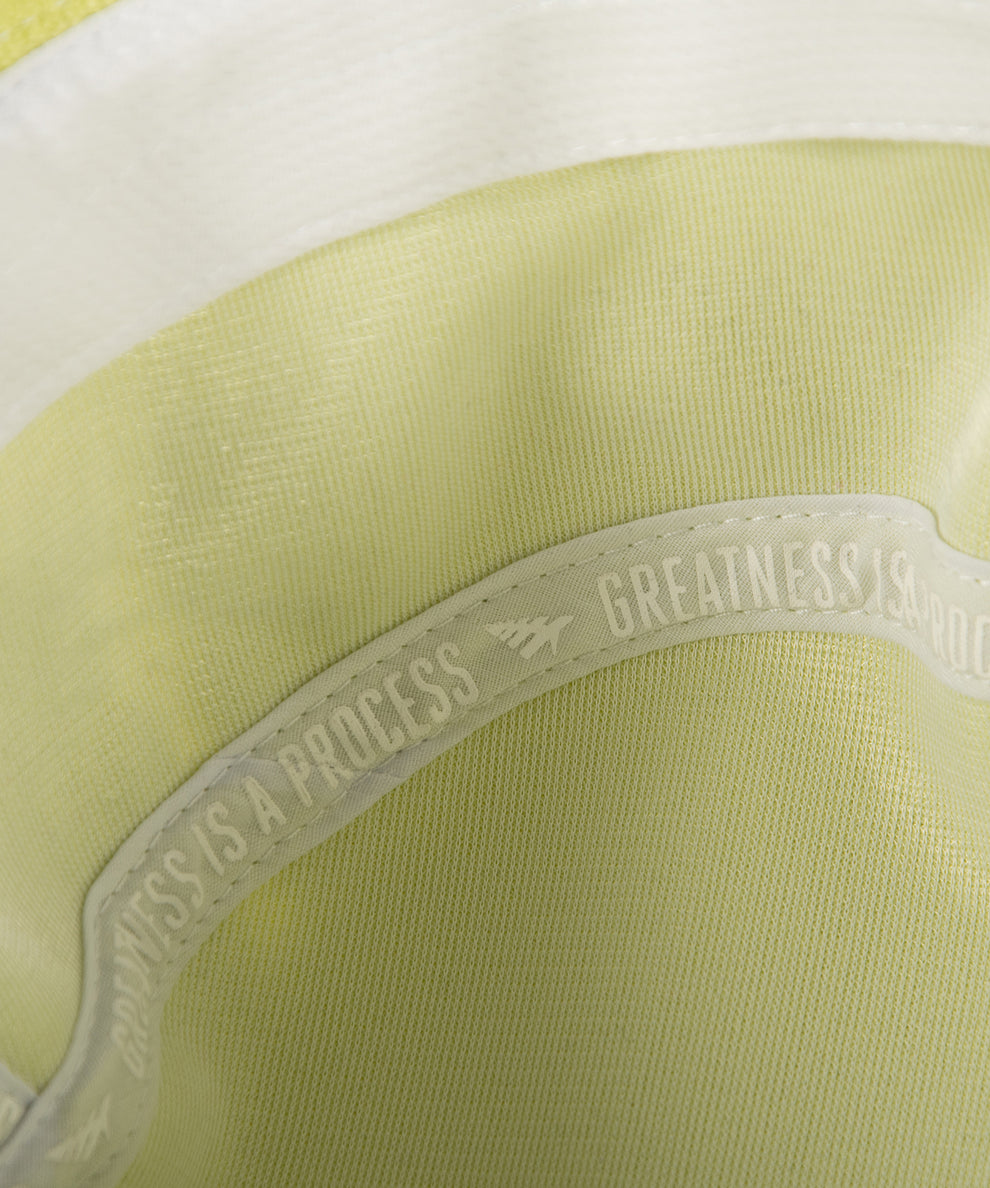 CUSTOM_ALT_TEXT: GREATNESS IS A PROCESS interior taping on Paper Planes Jacquard Terry Cloth Bucket Hat color Lime Sherbet.
