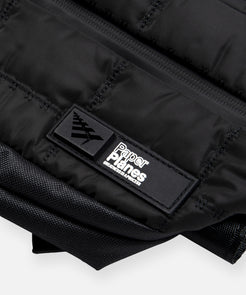 CUSTOM_ALT_TEXT: High-density silicone logo patch on Paper Planes Quilted Sling Bag.