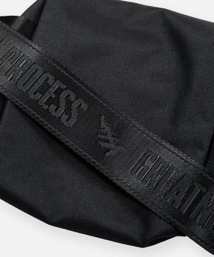 CUSTOM_ALT_TEXT: GREATNESS IS A PROCESS tonal jacquard webbing strap on Paper Planes Quilted Sling Bag.