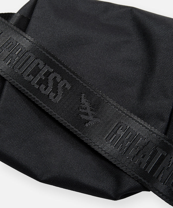 CUSTOM_ALT_TEXT: GREATNESS IS A PROCESS tonal jacquard webbing strap on Paper Planes Quilted Sling Bag.
